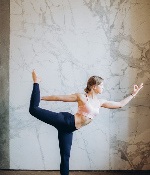 Woman in a graceful yoga pose, finding balance and peace indoors.